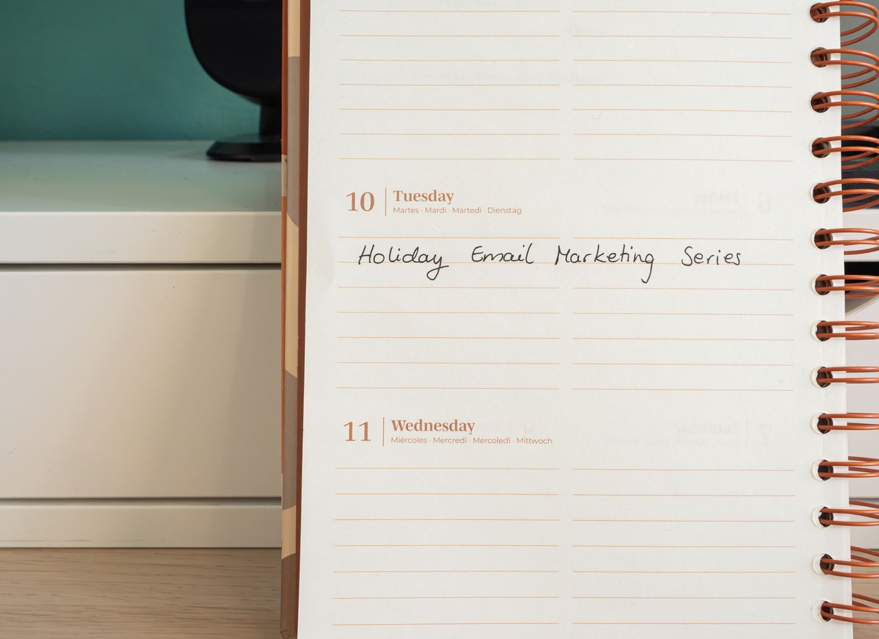 gallery-05 A planner lies open on a desk with a handwritten note reading Holiday Email Marketing Series.